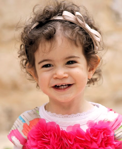 child smiling in a flowered dress